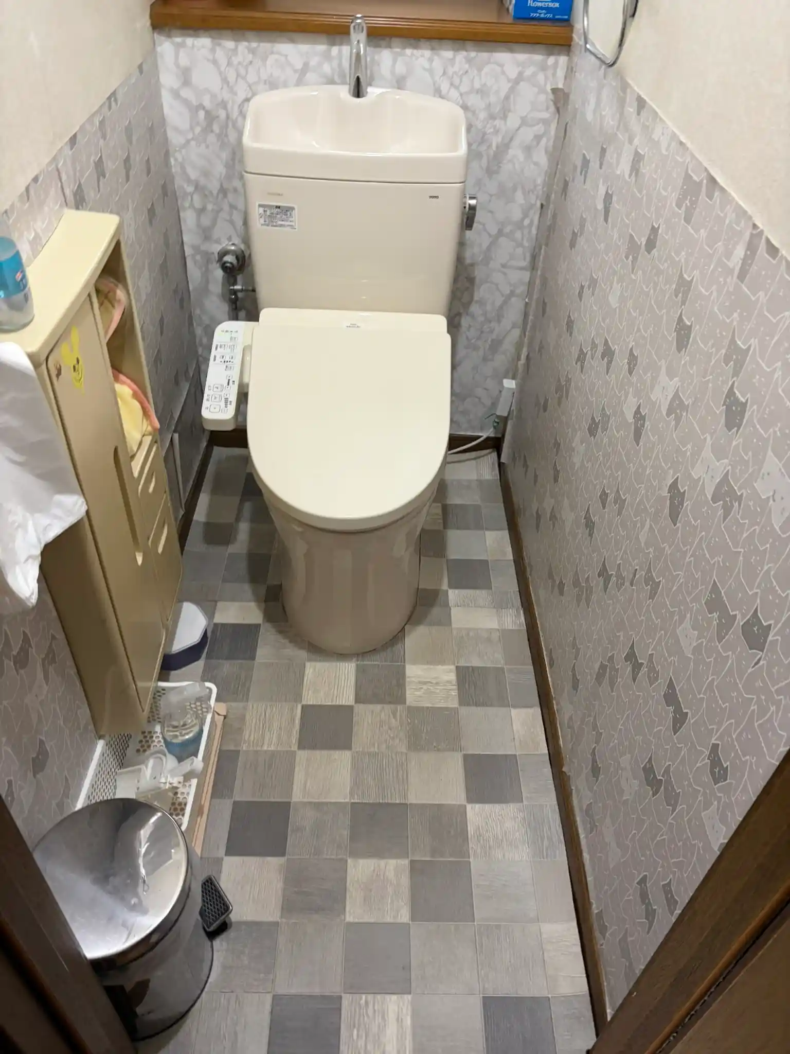 お客様が猫の傷を隠すために部分的に貼ったクロスが剥がれてきている様子(傷自体はクロスの下に隠れて見えない)。床は張り替え前のクッションフロア