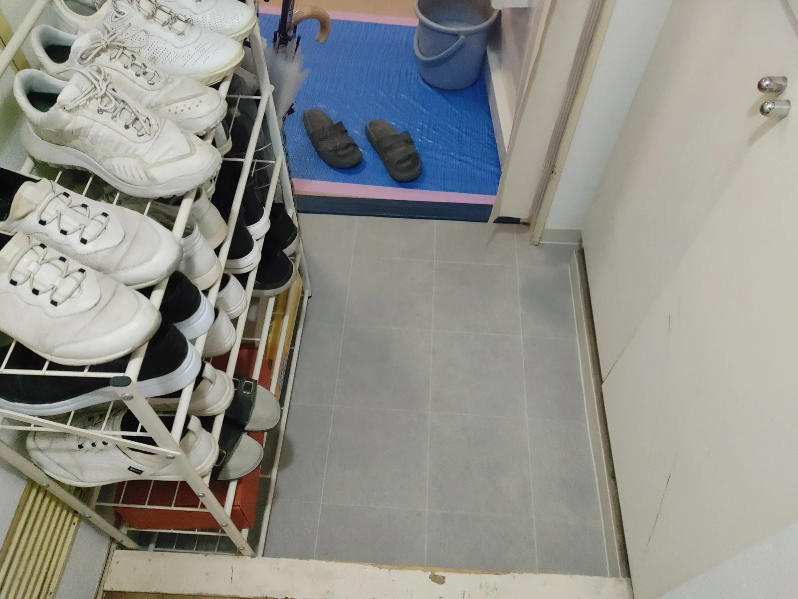 グレー系タイル柄のクッションフロアに張り替えられた三和土(玄関の土間)の様子