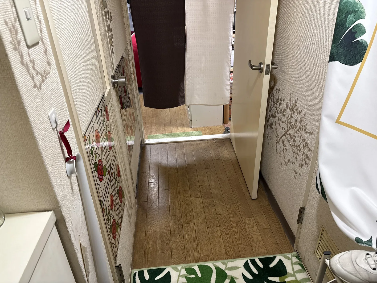リフォーム前の廊下。奥の部屋との間に装飾ガラス風のドアが見える様子