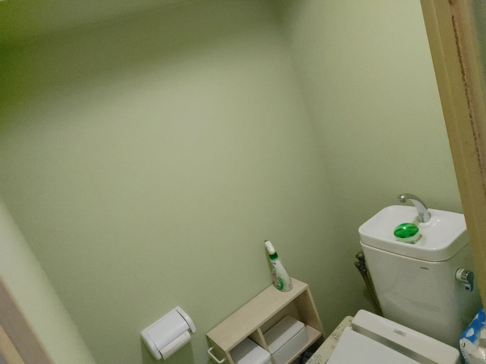 淡いグリーン系の新しいクロスに張り替えられ、明るい印象になったトイレの様子