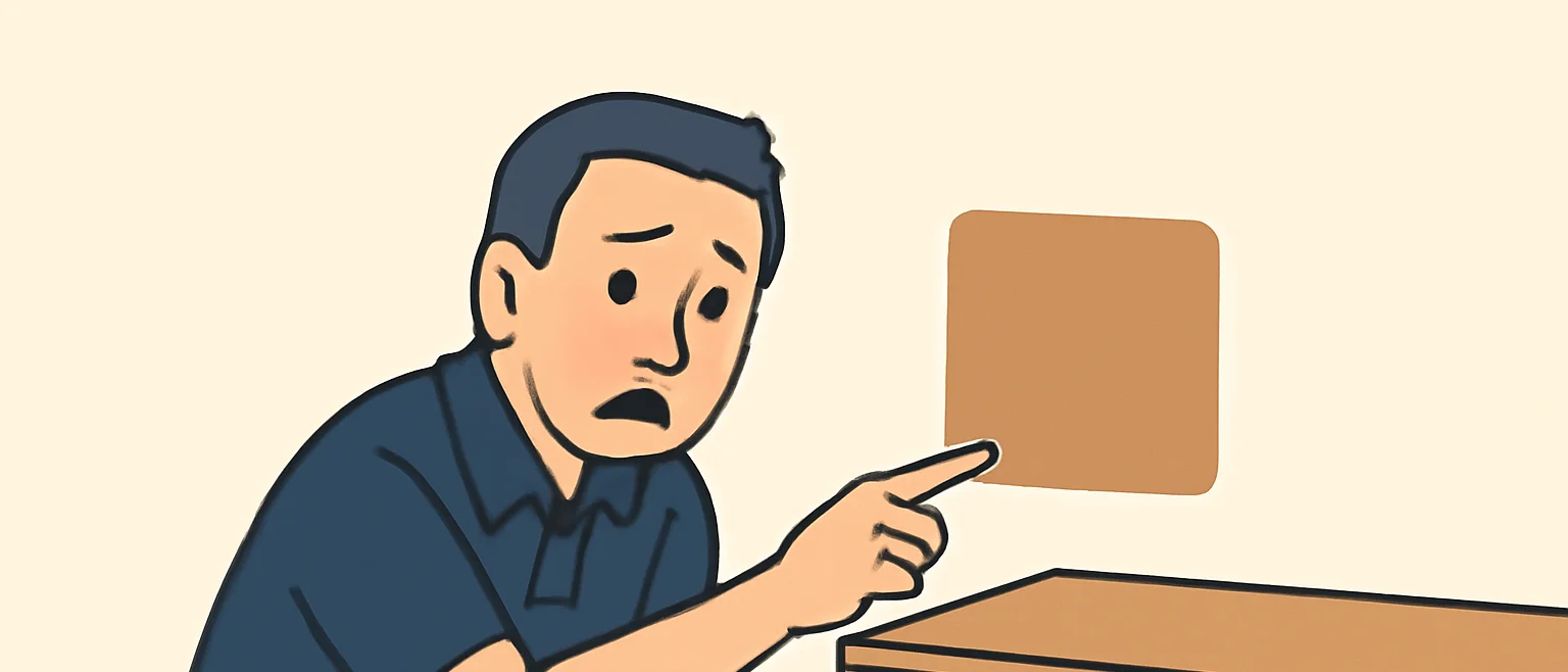 家具を少しどかしたところ、壁に家具の跡の形をした色移りのシミを見つけて指さす男性