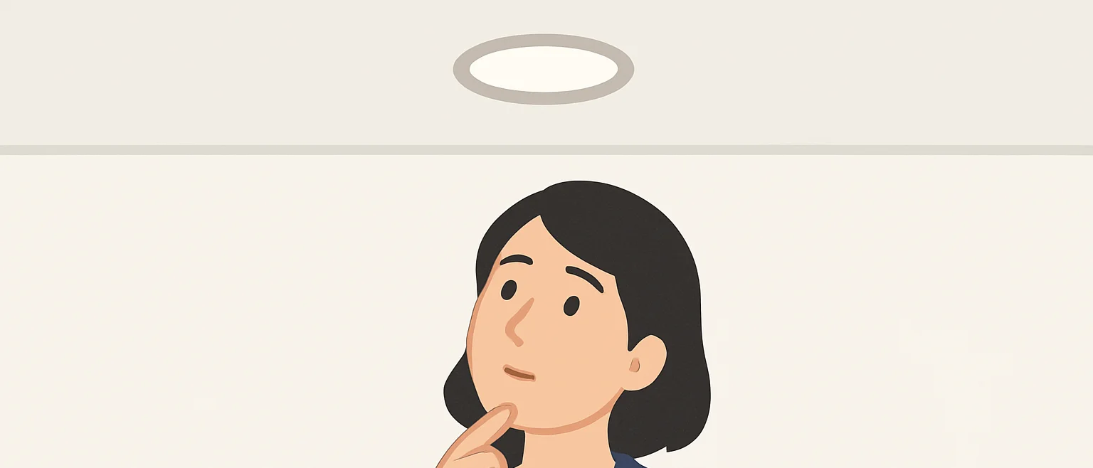 天井のダウンライトを見上げ、外すべきか思案する女性