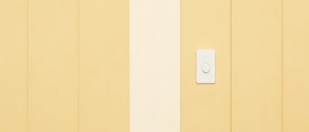 年数が経って黄ばんだ壁紙の中に、縦1枚分だけ新しく張り替えた白い壁紙があり、周りと色が違って見える様子