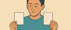壁紙の見本を両手に持ち見比べる男性。左は滑らかなビニールクロス、右は織り目のある壁紙