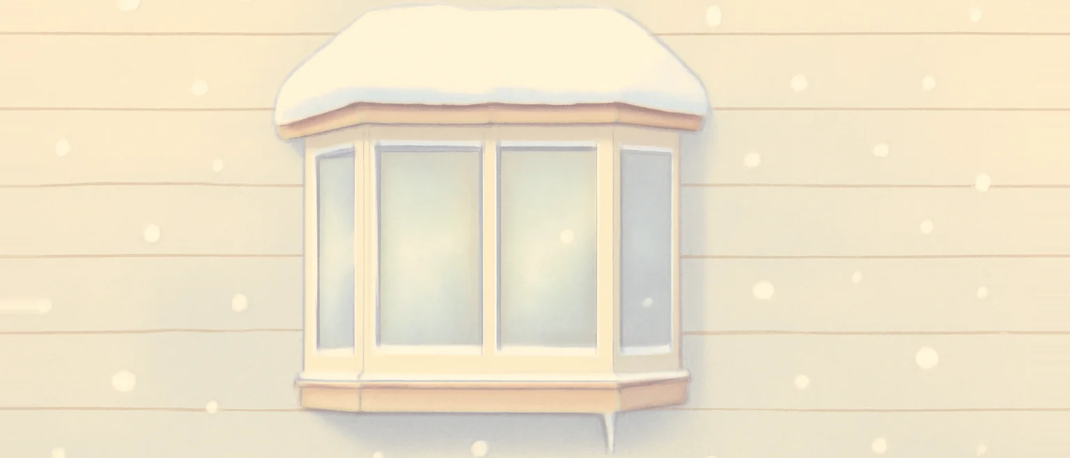 雪の降る日に外から見た家の出窓。壁から箱のように張り出し、屋根に雪が積もり、下につららが下がっている