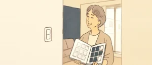 壁紙の見本帳を開き、白っぽい見本と濃紺の見本を見比べている女性