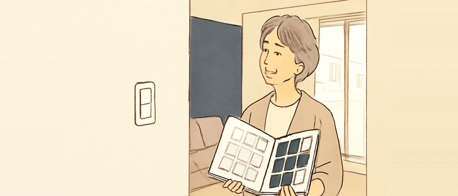 壁紙の見本帳を開き、白っぽい見本と濃紺の見本を見比べている女性
