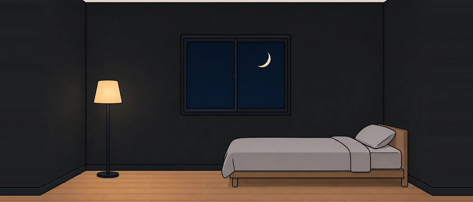 壁が黒に近い濃い色の寝室を夜に見た様子。窓の外は暗く、ランプのまわりだけが明るい