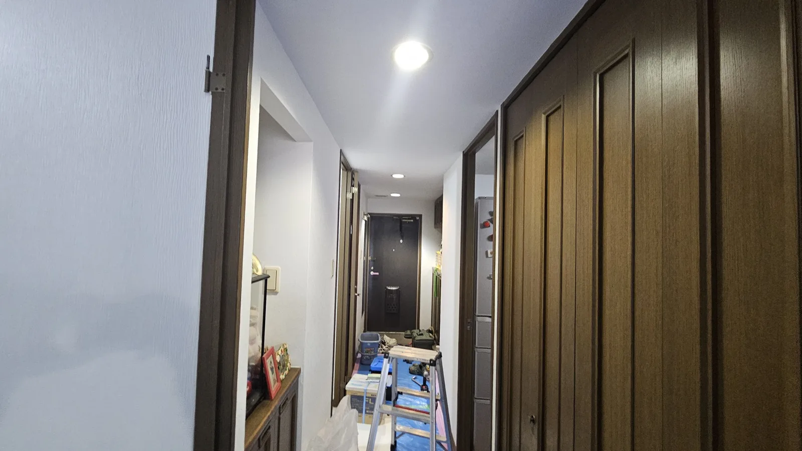 施工後の廊下。玄関に向かって見たところ。白い壁紙に張り替えた状態