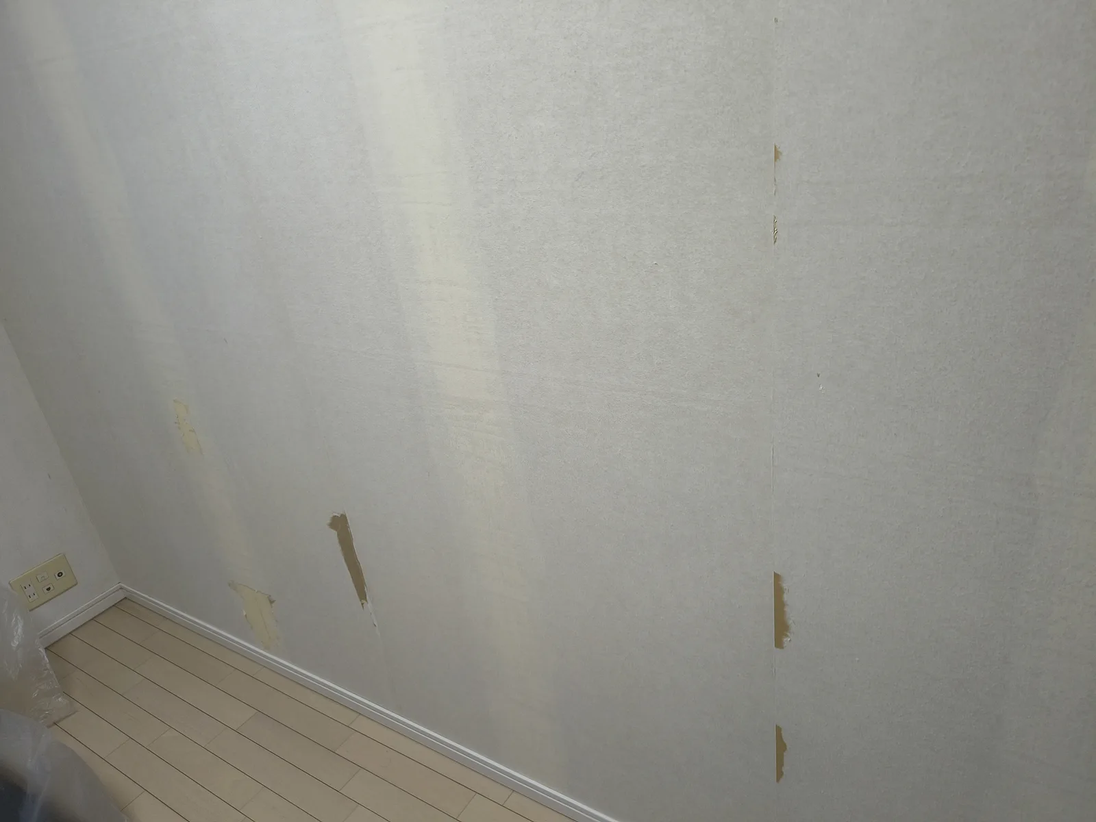 張り替え当日、壁紙を張る前の下地。裏紙が破れた箇所がいくつか残っている