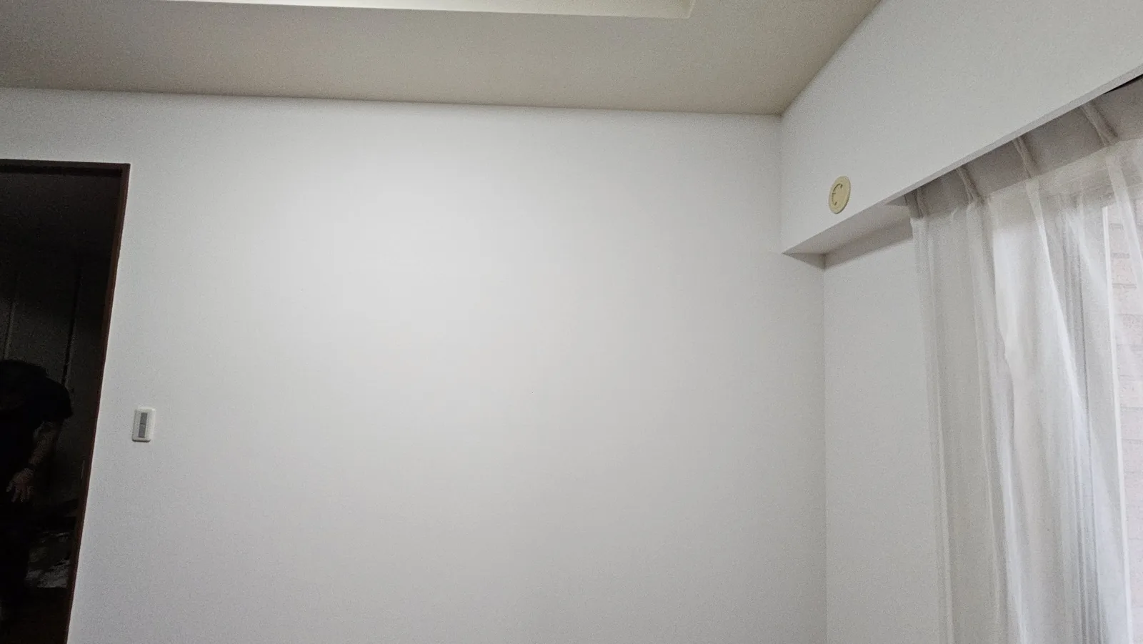 施工後の窓のある角。白い壁紙に張り替えた状態