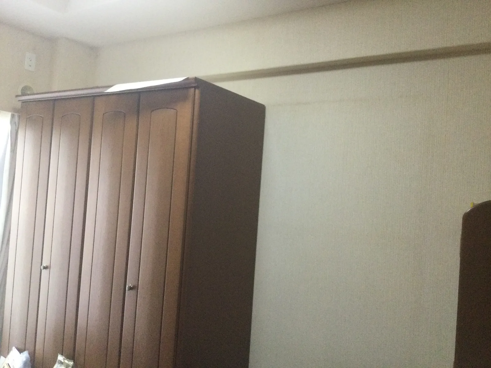 施工前の、大きなタンスが置かれた壁