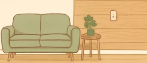 白い壁と、片側だけ木目調の壁がある部屋に、ソファと観葉植物を置いた様子