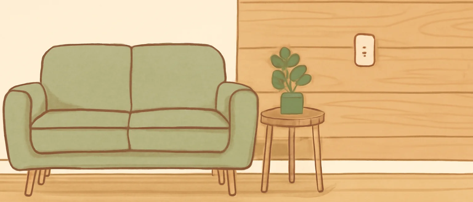 白い壁と、片側だけ木目調の壁がある部屋に、ソファと観葉植物を置いた様子